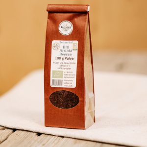 Packung Bio Aronia Beeren Pulver vom Zehnerhof, regionale Lungauer Spezialität auf Holzbrett