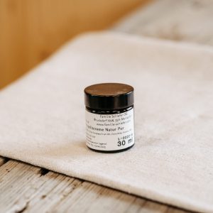 Kleine Dose Propoliscreme Natur Pur aus dem Lungau auf rustikalem Holztisch im Hofladen