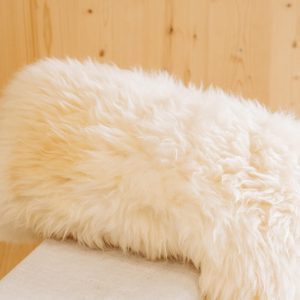 Natürliches, flauschiges Schaffell aus dem Lungau vor hellem Holz, regionale Spezialität