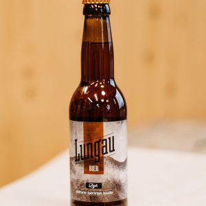 Braune Flasche Lungau Bier auf Holztisch, regionale Spezialität aus dem Salzburger Land