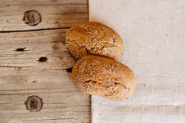 Zwei Sesambrötchen aus regionaler Lungauer Produktion auf Holz und Leinentuch, Hofladen