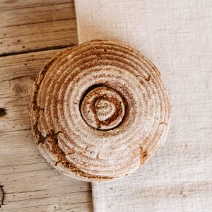 Rundes Bauernbrot aus dem Lungau auf rustikalem Holztisch, regionale Spezialität Hofladen
