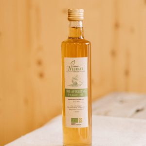 Flasche Bio-Apfelessig vom Biobauernhof Neumayr auf hellem Holztisch, regionale Spezialität Lungau
