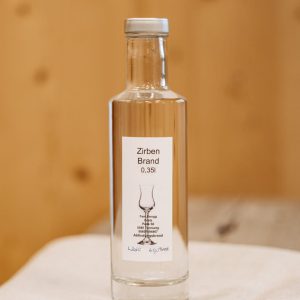 Flasche Zirbenbrand 0,35 l aus regionaler Lungauer Produktion auf Holzuntergrund, Spezialität