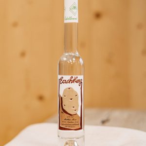 Flasche Lungauer Edelbrand Rachleng auf rustikalem Holztisch, regionale Spezialität Lungau