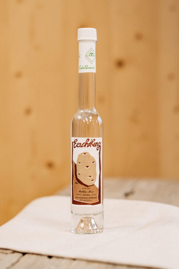 Flasche Lungauer Edelbrand Rachleng auf rustikalem Holztisch, regionale Spezialität Lungau