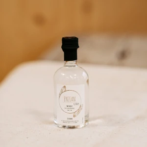 Kleine Flasche Enzianschnaps auf Holztisch, regionale Spezialität aus dem Lungauer Speis
