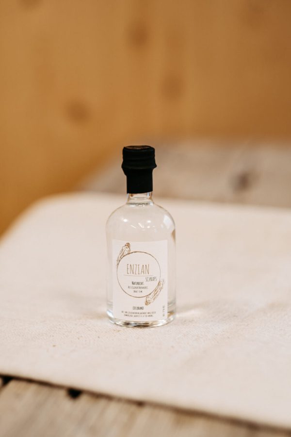 Kleine Flasche Enzianschnaps auf Holztisch, regionale Spezialität aus dem Lungauer Speis