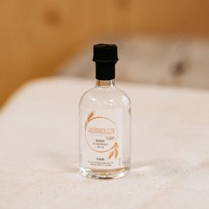 Kleine Flasche Tauernroggen Schnaps aus regionaler Lungauer Landwirtschaft auf Holzuntergrund