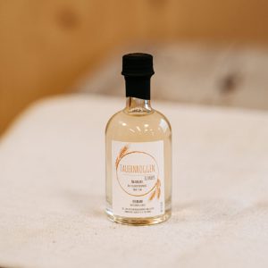 Kleine Flasche Tauernroggen-Schnaps aus regionaler Lungauer Produktion auf Holztisch