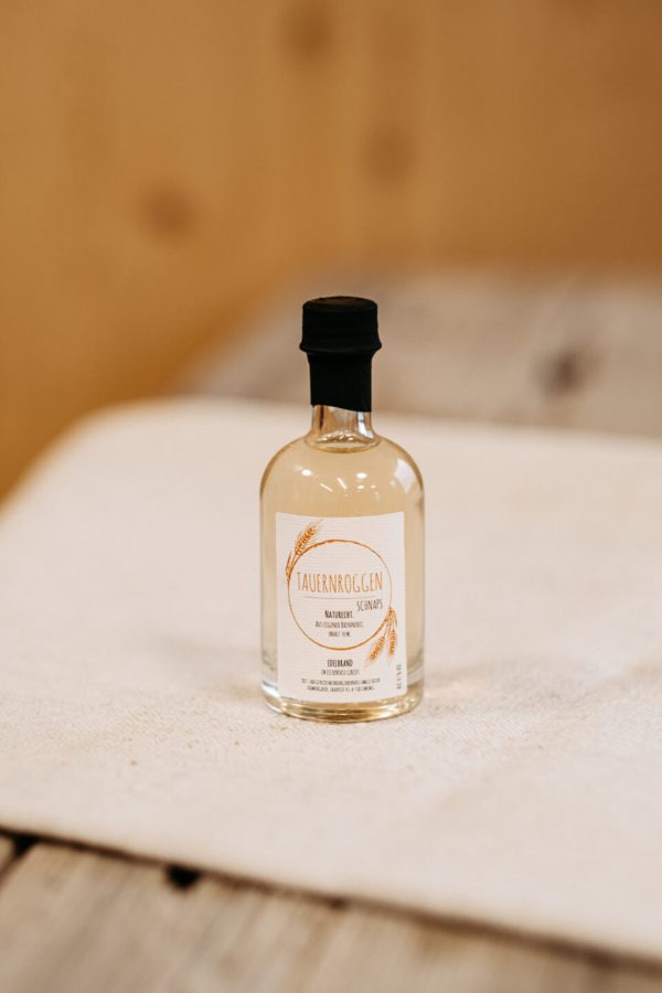 Kleine Flasche Tauernroggen-Schnaps aus regionaler Lungauer Produktion auf Holztisch