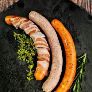 Drei Lungauer Würste mit Kräutern auf Schieferplatte, regionale Spezialitäten aus dem Lungau
