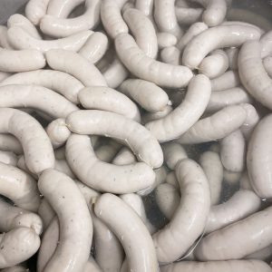 Frische Weißwürste in heißem Wasser in einer Metzgerei im Lungau
