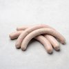 Fünf frische weiße Bratwürste aus regionaler Lungauer Produktion auf hellem Untergrund