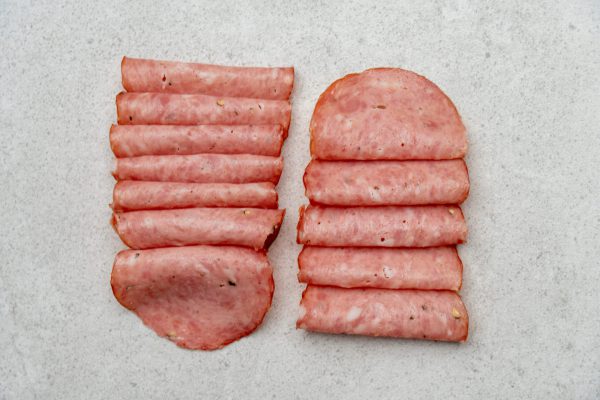 Aufgeschnittene Lungauer Wurstspezialitäten aus regionaler Metzgerei auf hellem Untergrund