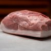 Frisches Stück Schweinefleisch aus regionaler Lungauer Landwirtschaft auf weißem Untergrund