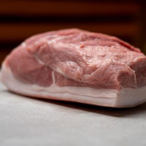 Frisches Stück Schweinefleisch aus regionaler Lungauer Landwirtschaft auf weißem Untergrund