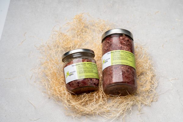 Zwei Gläser Lungauer Speis Tiernahrung mit Fleisch auf Stroh, regionale Spezialität aus Lungau